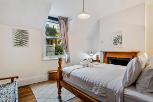 Un dormitorio con una cama y una chimenea. en Karkalla Terrace - Explore Hobart's Historic Heart, en Sandy Bay