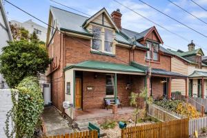 una casa de ladrillo con toldo verde en Karkalla Terrace - Explore Hobart's Historic Heart, en Sandy Bay 11 fotos más