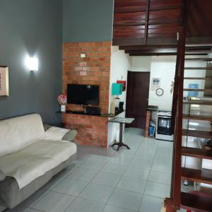 a living room with a couch and a brick wall at FLAT GRAVATÁ WINTERVILLE 1214 in Gravatá
