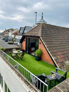 a brick house with a yard with green grass at Modern, centrally located, beach view flat in Pevensey