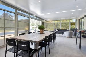 un gran comedor con una gran mesa de madera y sillas en HOT HOT Spoil someone special at this luxe Hunter Valley Estate - stunning luxury in super central location en Nulkaba