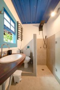 a bathroom with a sink and a toilet at Casas do Pátio Pousada & Bar in Paraty