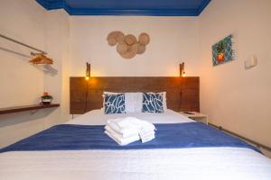 a bedroom with a bed with towels on it at Casas do Pátio Pousada & Bar in Paraty