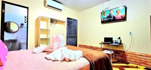 a bedroom with a bed with a tv on the wall at Hotel Cida Flats - Apartamento Charmoso com 300 Mbps in Boa Vista