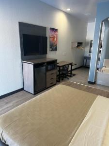 a living room with a flat screen tv and a table at M&M Inn and Suites in Fort Worth