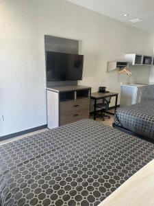 a bedroom with a bed and a flat screen tv at M&M Inn and Suites in Fort Worth