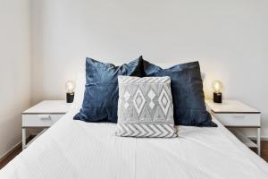 een slaapkamer met een wit bed met blauwe kussens bij Convenient Kensington living Great Location in Melbourne
