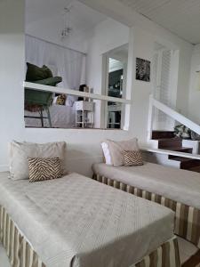 1 dormitorio con 2 camas y espejo en Barracuda Eco Resort Búzios, en Búzios