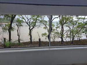 een raam met uitzicht op een waterlichaam bij Barracuda Eco Resort Búzios in Búzios