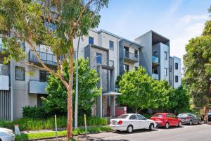 een appartementencomplex met auto's geparkeerd op een parkeerplaats bij Convenient Kensington living Great Location in Melbourne