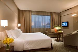 シンガポールにあるYork Hotelの大きなベッドと椅子が備わるホテルルームです。