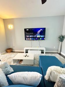 a living room with a blue couch and a tv at Uptown CLT - Modern Townhouse in Charlotte