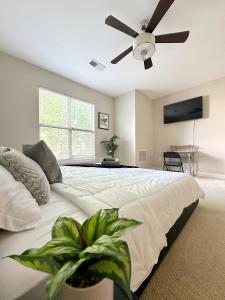 a bedroom with a large bed with a ceiling fan at Uptown CLT - Modern Townhouse in Charlotte