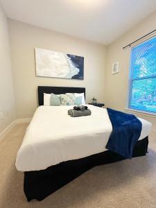 a bedroom with a large white bed with a blue blanket on it at Uptown CLT - Modern Townhouse in Charlotte