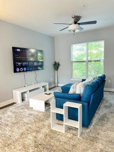 a living room with a blue couch and a tv at Uptown CLT - Modern Townhouse in Charlotte