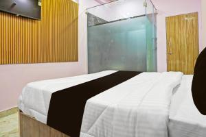 1 dormitorio con 1 cama y ducha acristalada en OYO The Orchid Hotel, en Nagpur