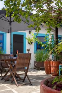 Casas do Pátio Pousada & Bar في باراتي: جلسة كرسي خشبي بجانب طاولة فيها مظلة