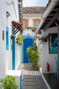a blue door on the side of a house at Casas do Pátio Pousada & Bar in Paraty