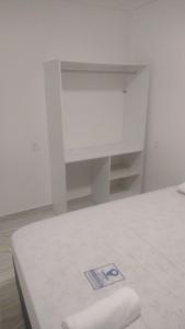 Habitación blanca con cama y armario blanco en HOTEL DA RODOVIARIA en Belém