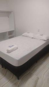 Una cama blanca con una toalla encima. en HOTEL DA RODOVIARIA en Belém