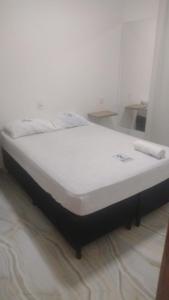 Cama blanca en habitación con espejo en HOTEL DA RODOVIARIA en Belém
