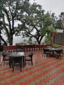 a group of tables and chairs on a brick patio at The Oaktree House in Shimla