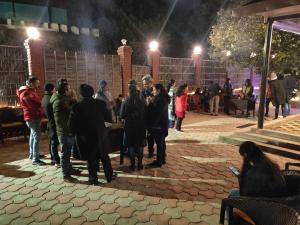 a group of people standing in a courtyard at night at The Oaktree House in Shimla