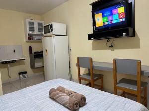 Habitación con cama y TV en la pared. en Capim dourado privativo a minutos do aeroporto, en Palmas