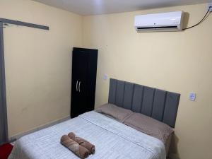 a bedroom with a bed and a air conditioner on the wall at Capim dourado privativo a minutos do aeroporto e rodoviária in Palmas