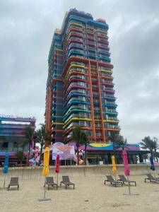 Thanh Hóaにあるkhách sạn Hoàng An - biển Hải Tiếnのビーチ沿いの大きな建物(椅子、パラソル付)