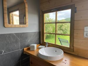 un bagno con un lavandino e una grande finestra di Nuit insolite en Tipi avec bain nordique privatif, petits déjeuners inclus a Médonville