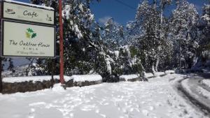 a sign in the snow next to a road at The Oaktree House in Shimla