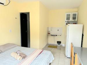 uma pequena cozinha com uma cama e um frigorífico em Capim dourado privativo a minutos do aeroporto e rodoviária em Palmas