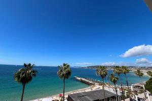 a view of a beach with palm trees at Juan les Pins - Sea View - 4 people - Parking in Juan-les-Pins