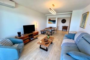 a living room with a blue couch and a table at Juan les Pins - Sea View - 4 people - Parking in Juan-les-Pins