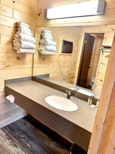 a bathroom with a sink and a mirror and towels at Sunrise Beach Motel in Mackinaw City