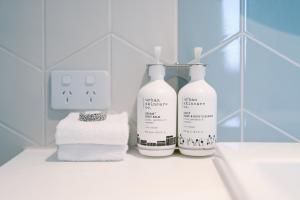 a bathroom with two bottles of soap and towels at Holiday Inn Express Sydney Airport, an IHG Hotel in Sydney