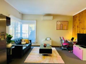 a living room with a couch and a table and a desk at Horsham Unit 1 Paddy's Golden Patch in Horsham