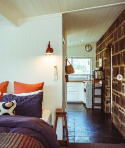 a bedroom with a bed and a brick wall at Ellerslie Cottage in Metcalfe