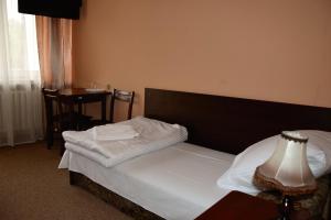 a bedroom with a bed and a table with a lamp at Hotel Poświętne in Płońsk +11 photos