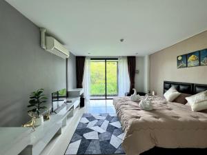 1 dormitorio con cama grande y ventana grande en The Pixels Cape Panwa Condo, en Phuket