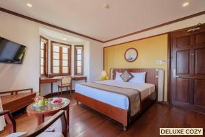 a hotel room with a bed and a desk at Sunny Beach Resort & Spa in Mui Ne