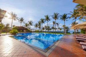 an image of a swimming pool at a resort with palm trees at Sunny Beach Resort & Spa in Mui Ne