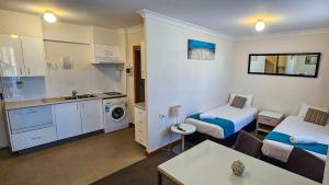 a small room with two beds and a kitchen at Copacabana Shores in Copacabana