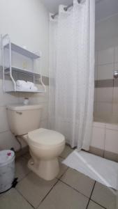 y baño blanco con aseo y ducha. en Habitacion baño Propio La Paz 1 en Lima
