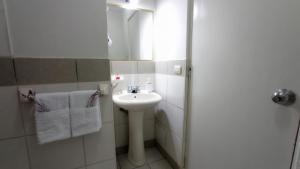 Habitacion baño Propio La Paz 1 في ليما: حمام أبيض مع حوض ومرآة