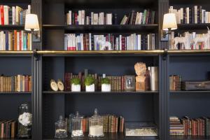 a bookshelf filled with books and bookshelves at Hotel De Nemours Rennes in Rennes