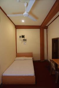 Cinnamon Airport Residencies في كاتوناياكى: سرير في غرفة بها مروحة سقف