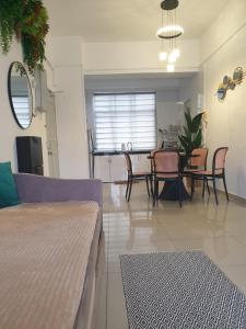 a living room with a couch and a table and chairs at 1Bedroom Urban Oasis Retreat in Melaka
