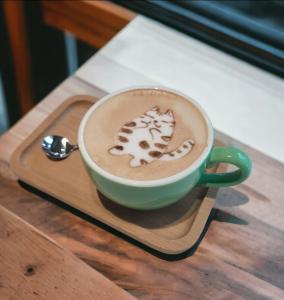 una tazza di caffè su un vassoio di legno con un cucchiaio di Mika BnB a Shih-t'ou-wei